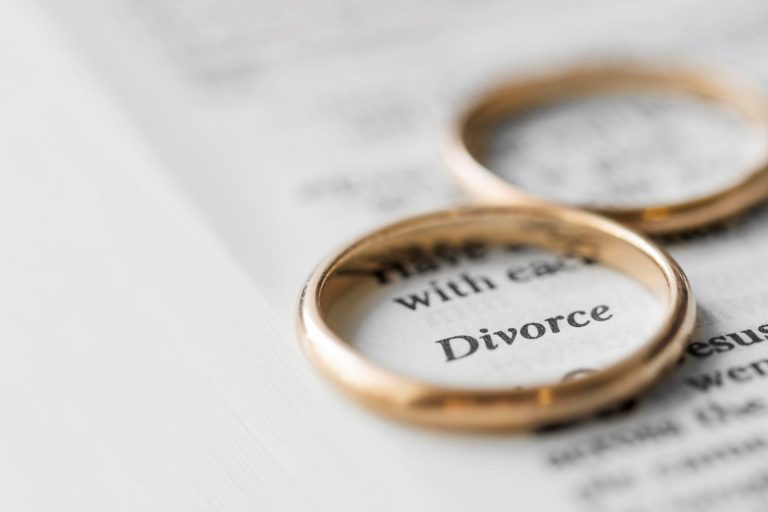 diivorce-rings-closeup-FP Closeup of wedding rings placed on page that reads "divorce" illustrates blog "5 Legal Tips To Prepare for Your Divorce"