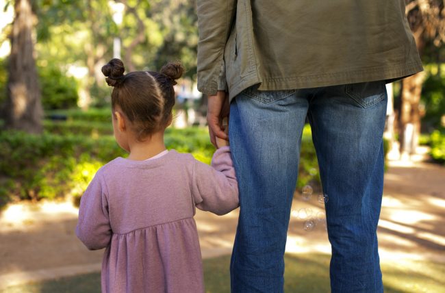 child-custody-fp Child holding hand of adult man seen from behind illustrate blog "How Is Child Custody Determined in California?"