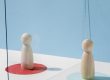 Two wooden figurines in red and blue circles respectively, illustrate blog "Child Custody: Understanding Your Rights and Options"