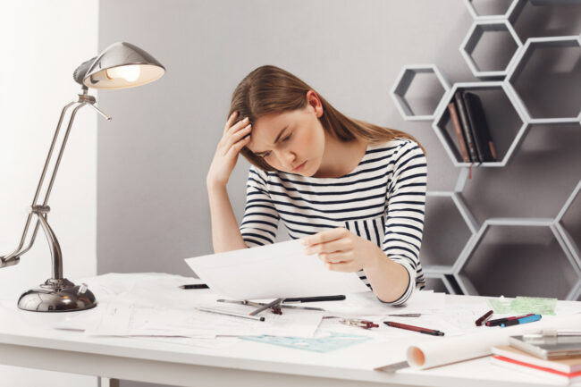 person stressed after they miss court date reviewing legal paperwork